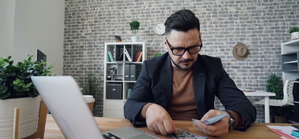 A firm owner working at a table with a laptop