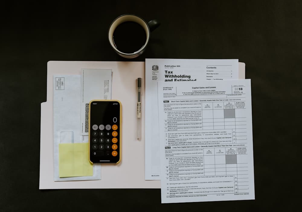 A phone and tax paperwork on an office desk