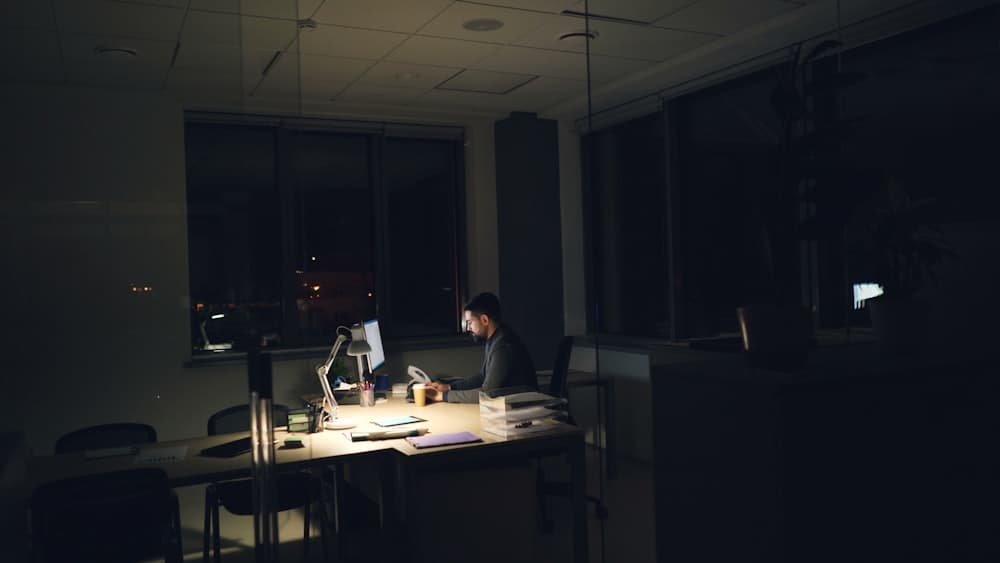 A person working late at a dimly lit office desk