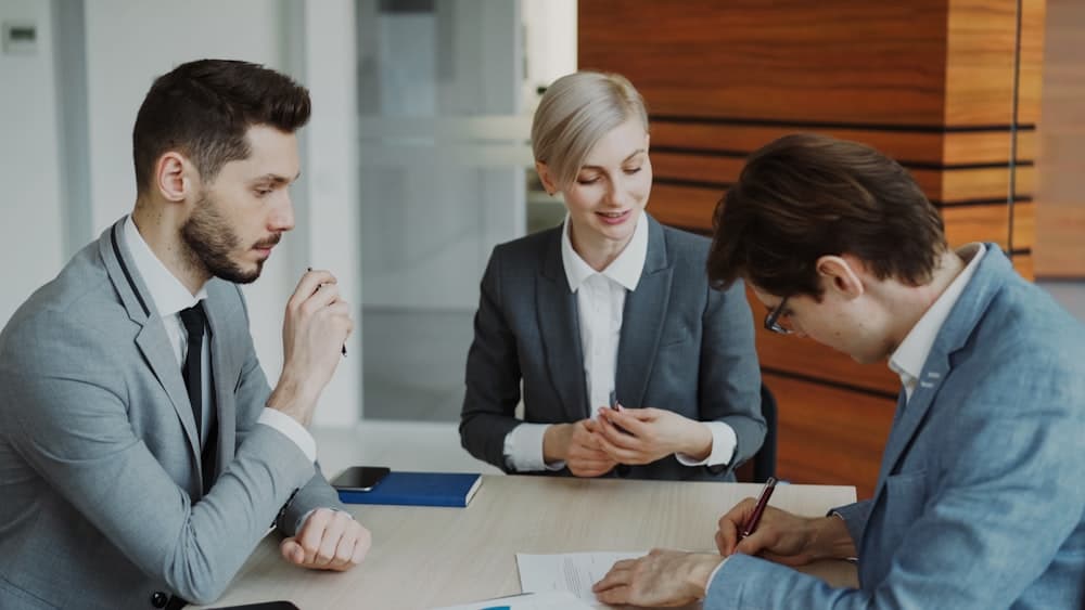 People signing a contract at a table