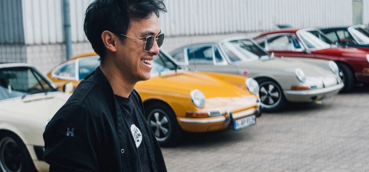 A man standing in front of a row of parked cars
