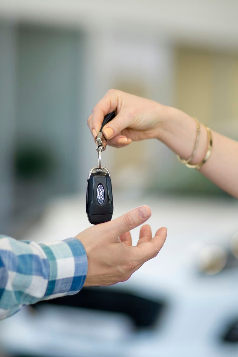 One person handing a car key to another