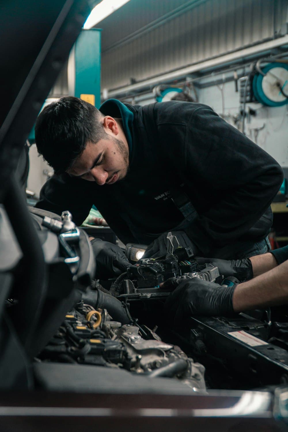 A technician looking over an engine bay in the shop