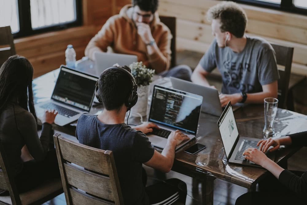 A small team working on laptops around a table