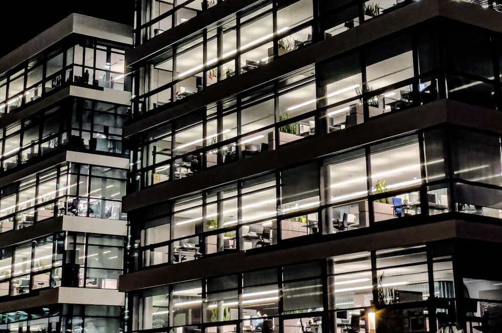 An office building lit up at night with empty desks inside
