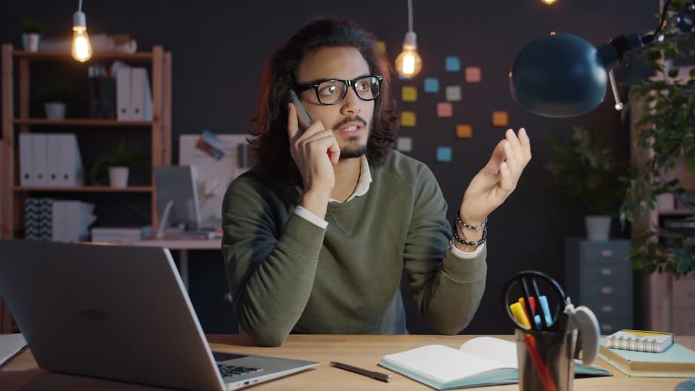 A person pricing a job by phone at an office desk