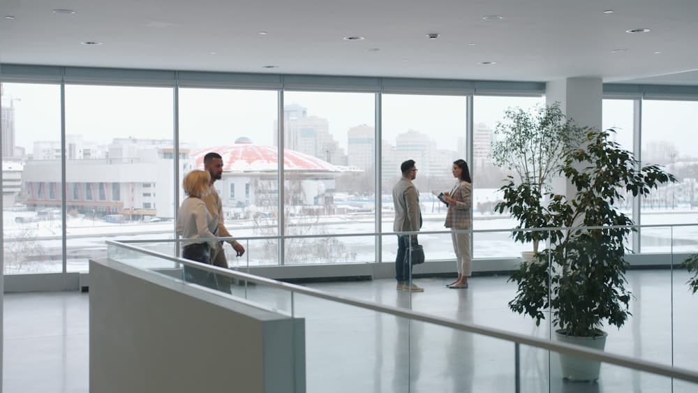 People talking on an upper floor of a glass office building