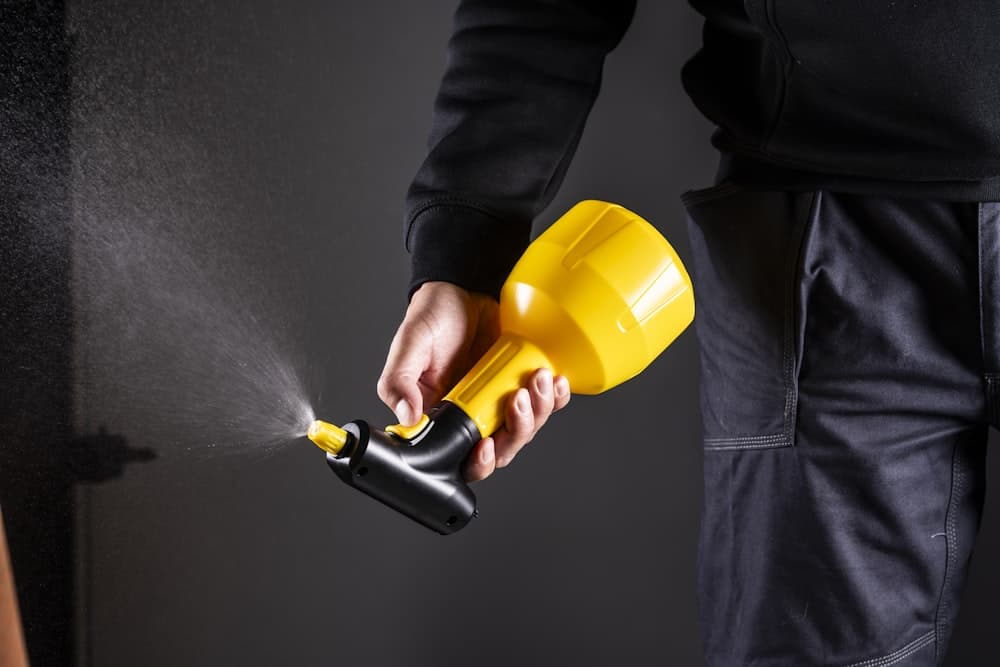 A technician holding a spray applicator