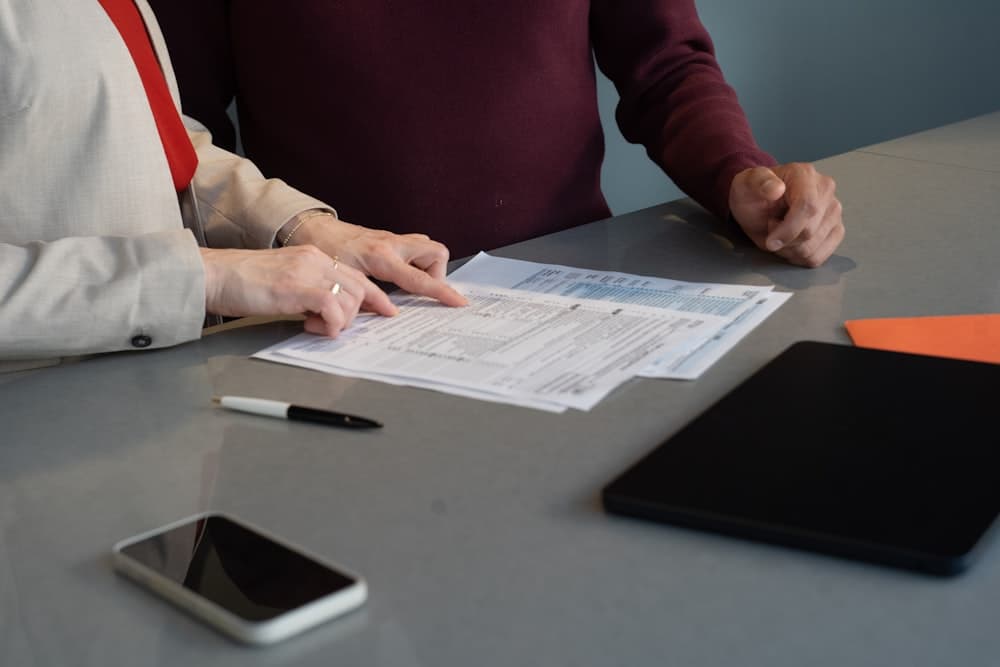 Two people going through application forms at a table