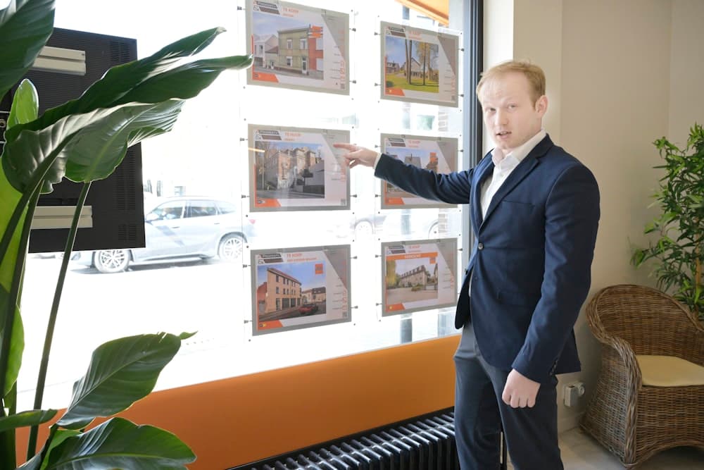 An agent pointing at property listings in an office window