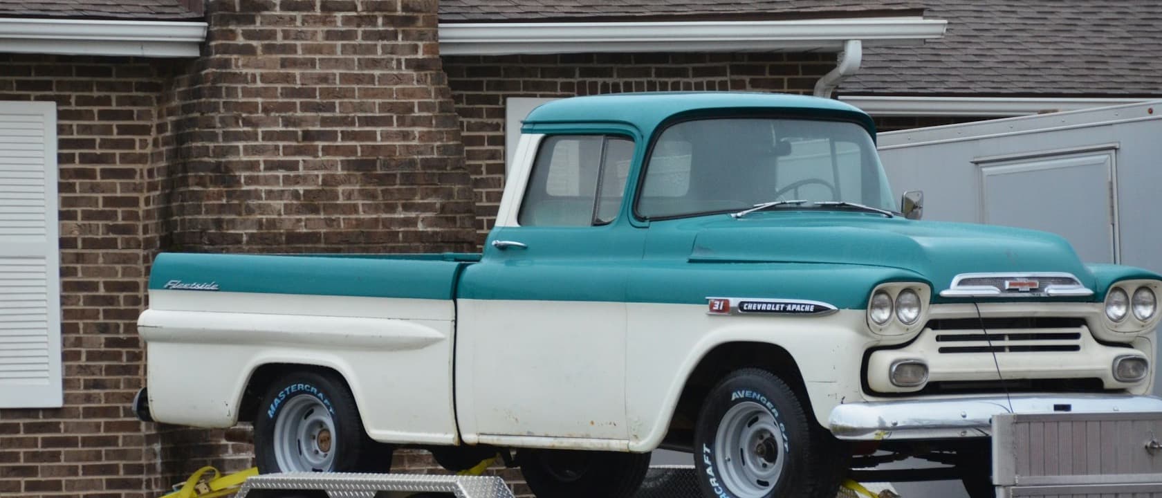 A work truck and trailer parked in front of a house