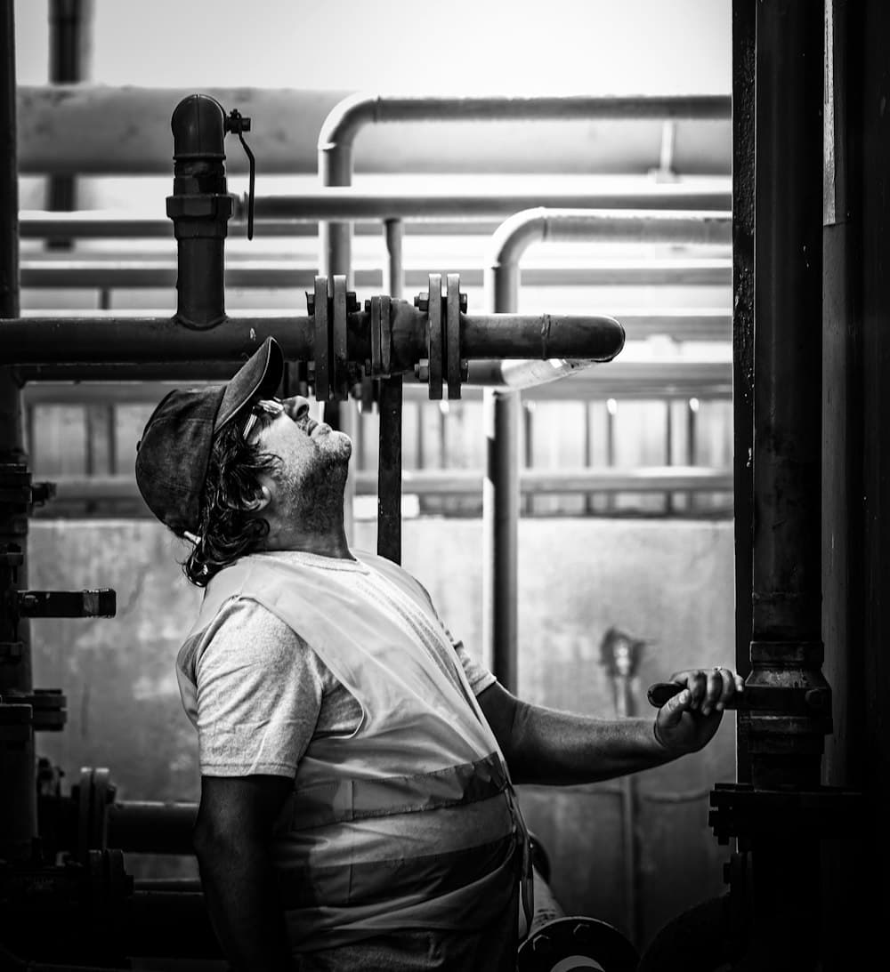 A worker inspecting industrial pipes and valves