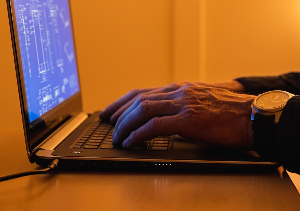 A person working at a laptop on an office desk