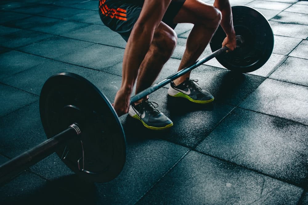 A lifter setting up under a barbell at the end of the day
