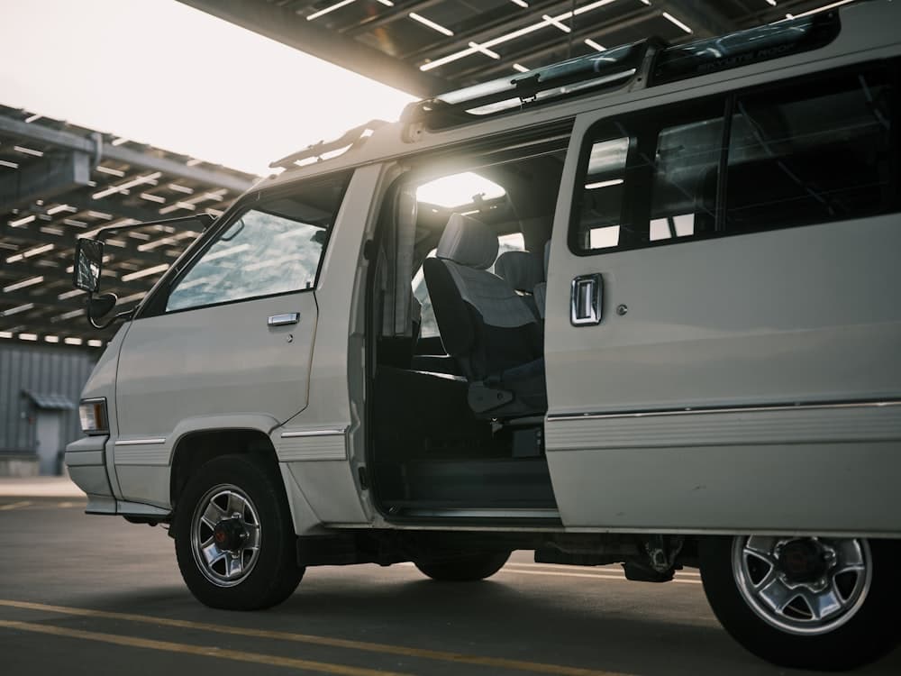 A white service van with its side door open in the morning light