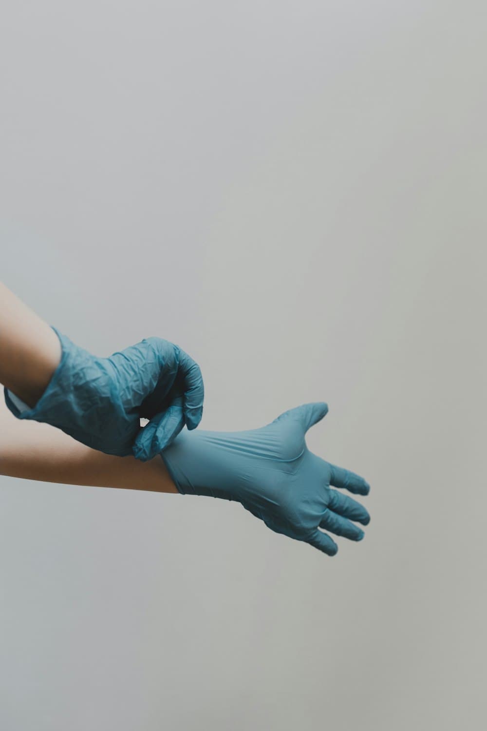 A gloved hand cleaning a surface with a spray bottle