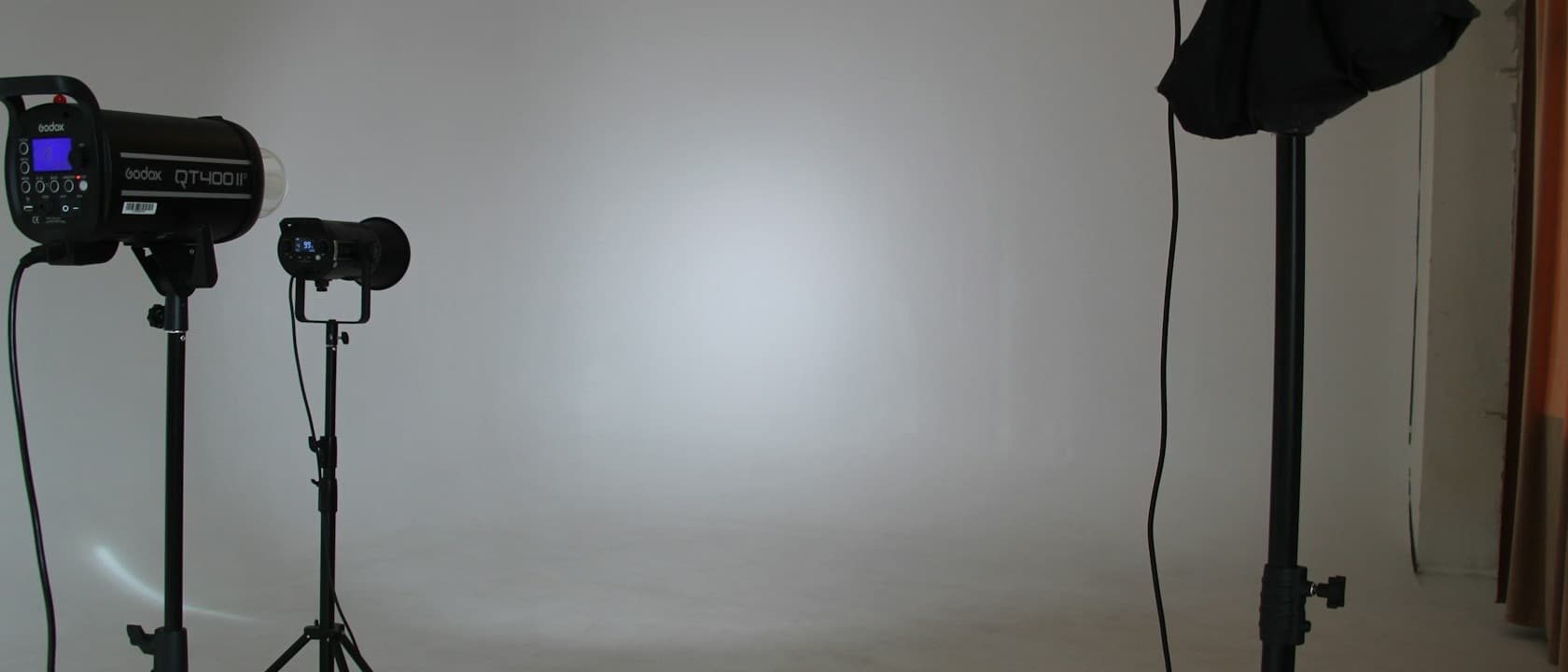 An empty photo studio with lighting rigs standing ready