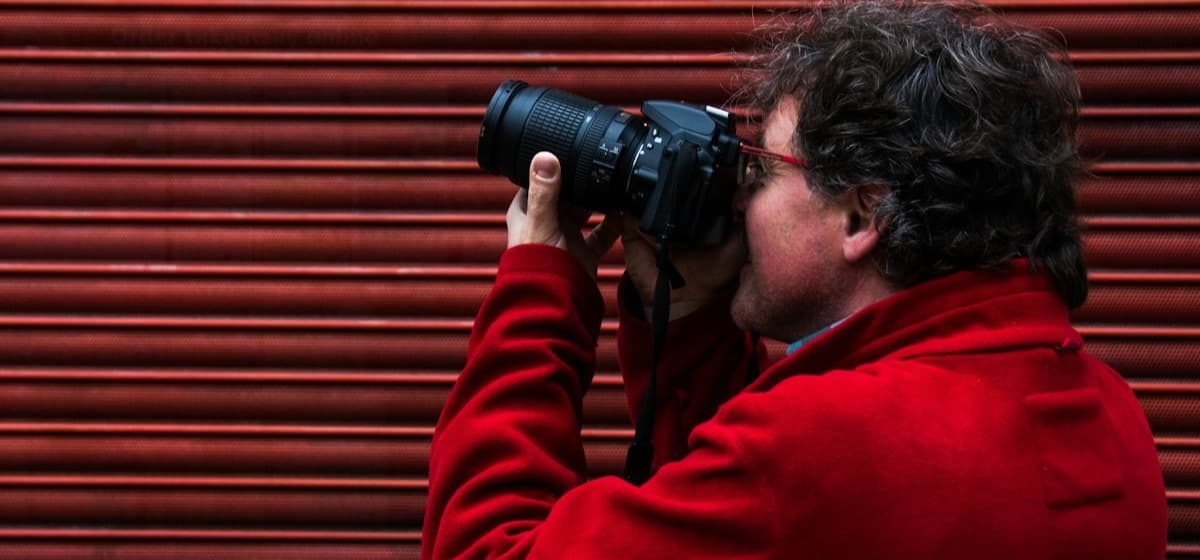 A photographer at work with a DSLR raised to the eye