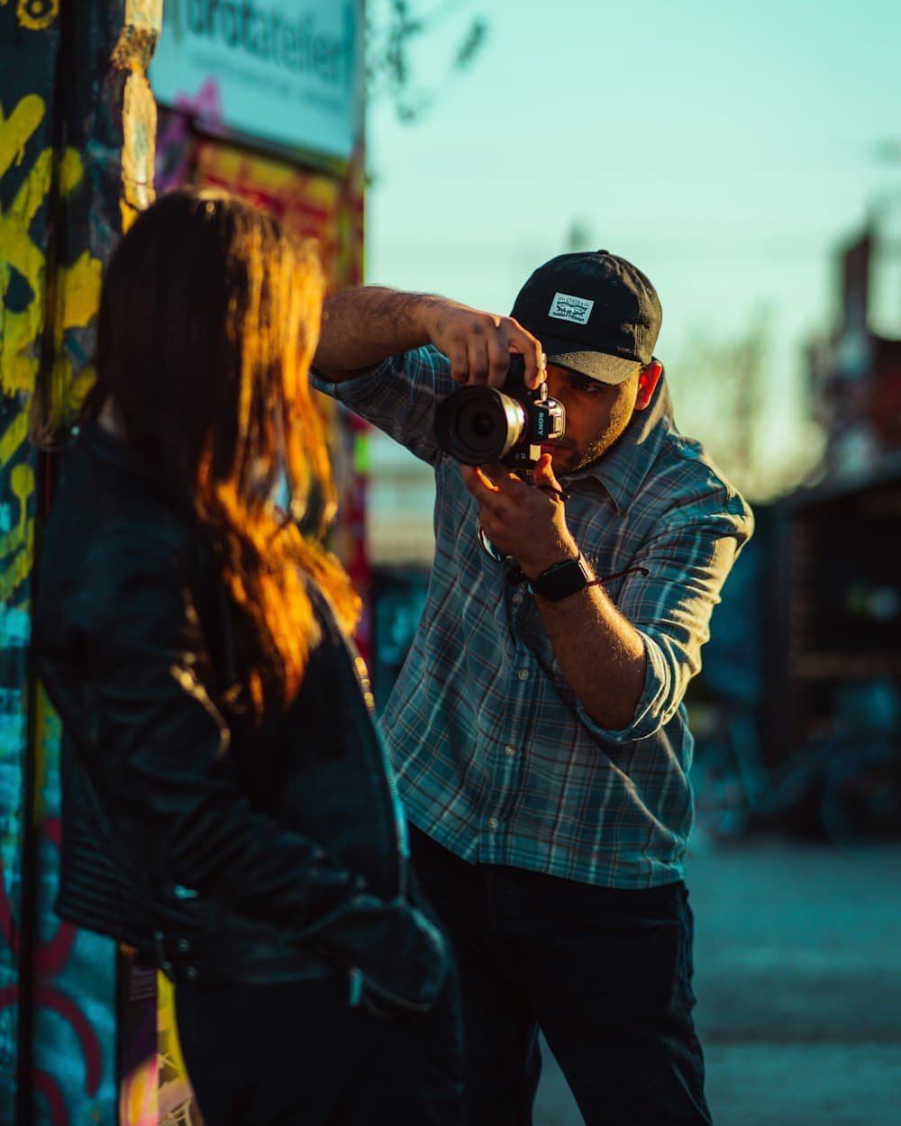 A photographer shooting a portrait session against a painted wall