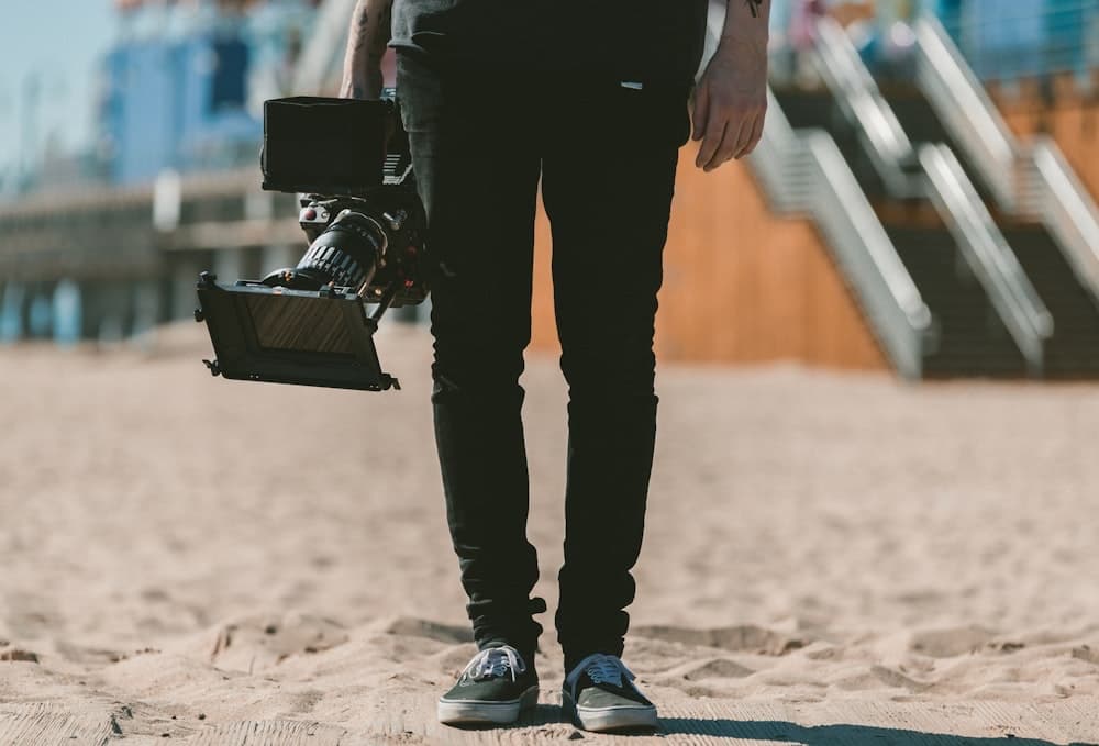 A videographer with a shoulder-mounted camcorder