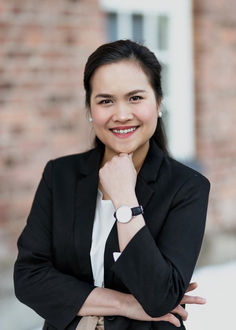 A woman in a black blazer, smiling