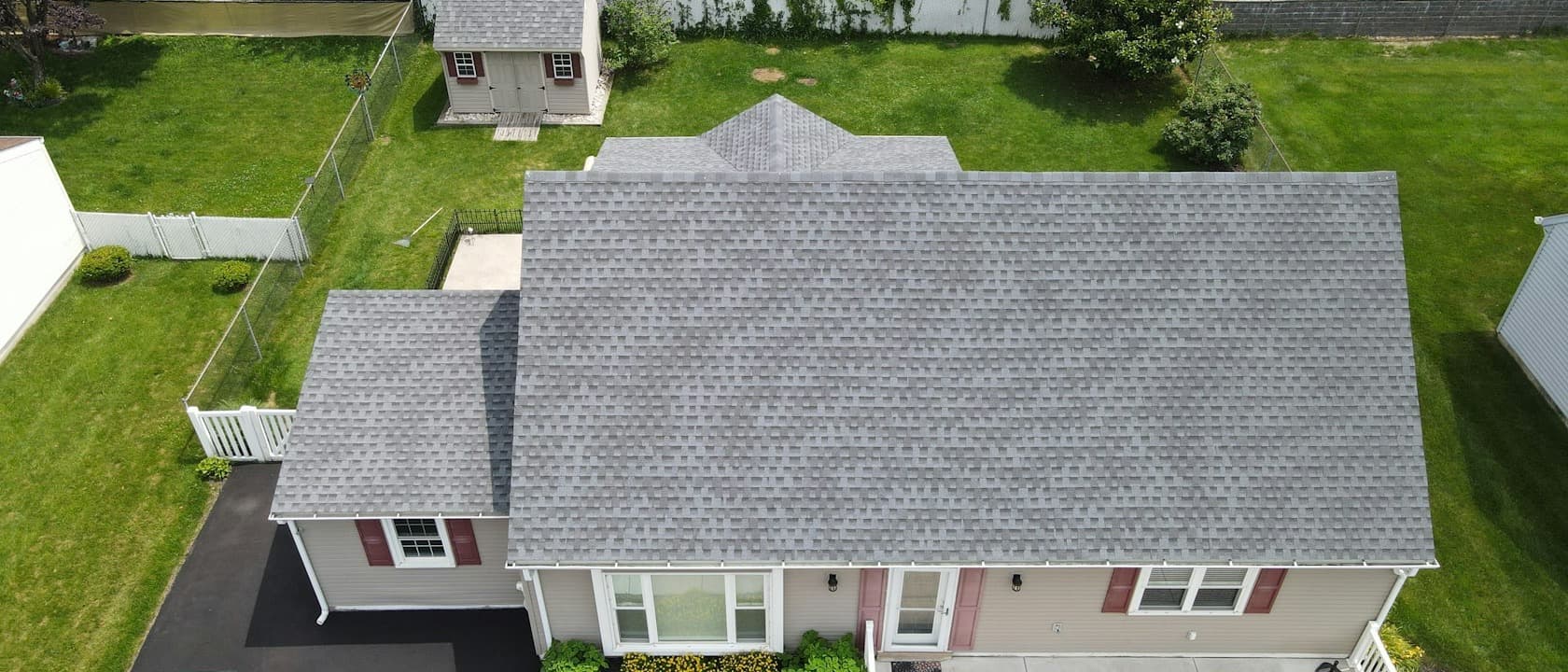 A finished grey shingle roof on a suburban house, seen from above