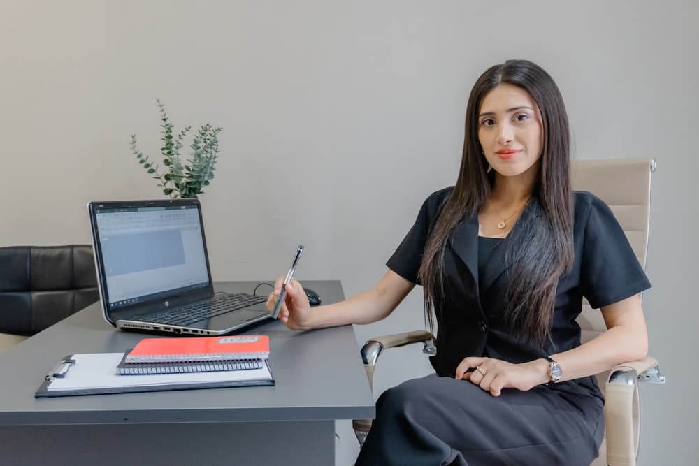 A person pricing a job at a desk with a laptop