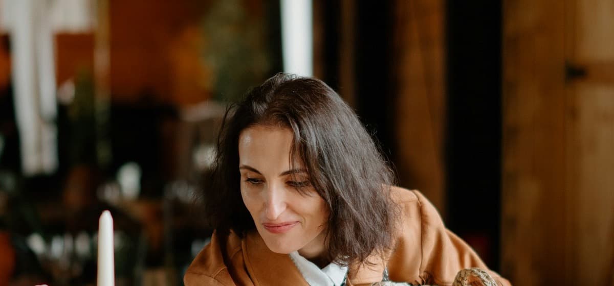 A planner leaning over a table mid-setup in a barn venue