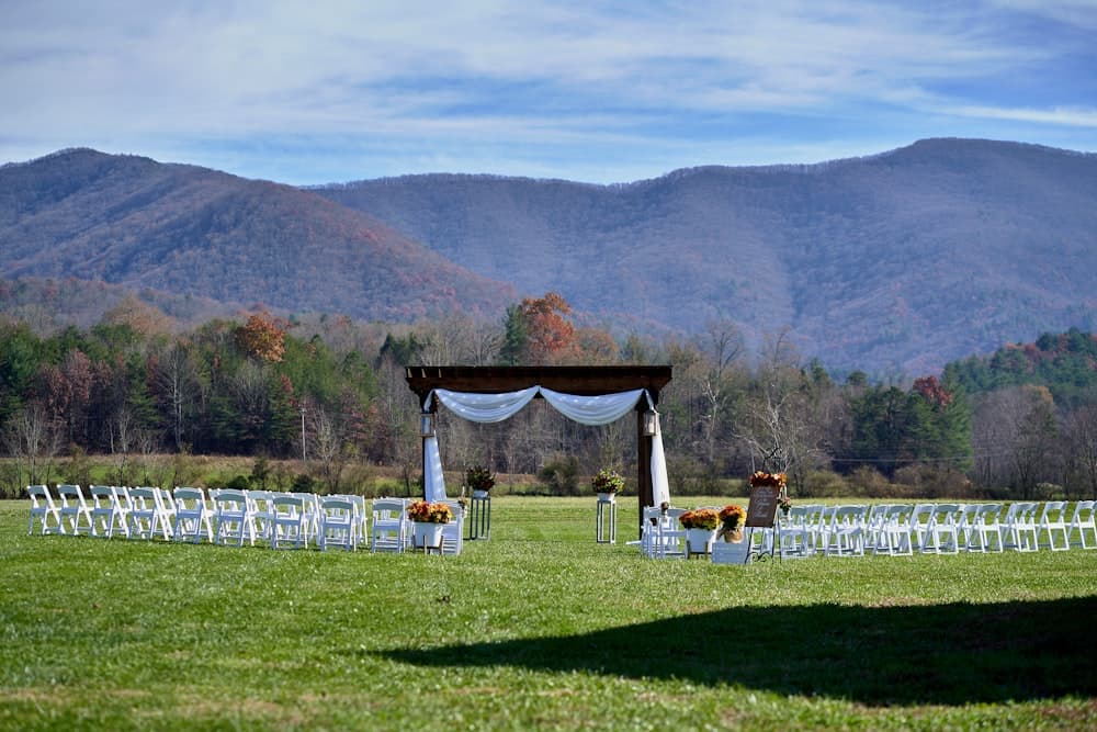 An outdoor ceremony arch and rows of chairs before the processional