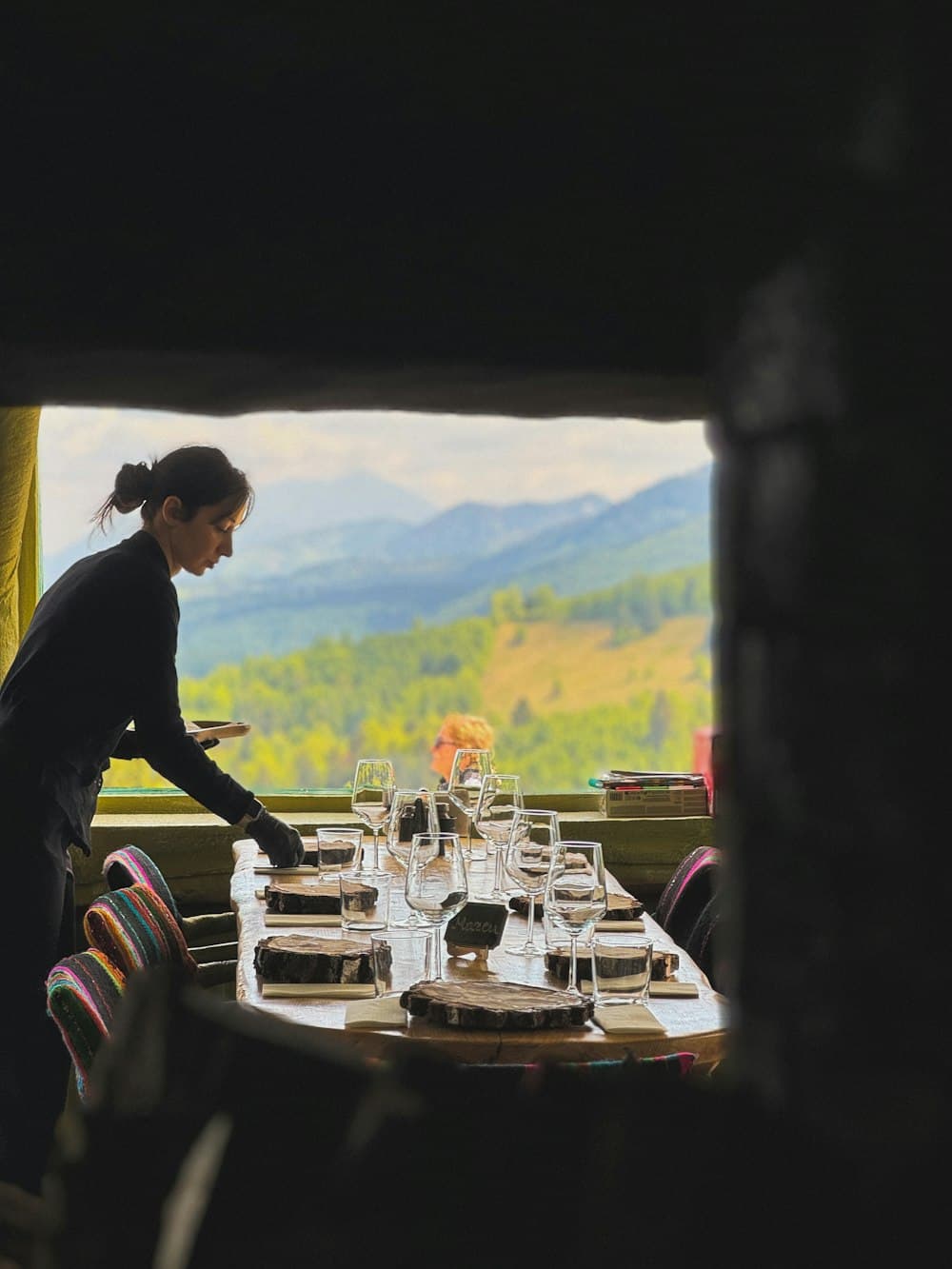 A planner laying plates down a long table before guests arrive