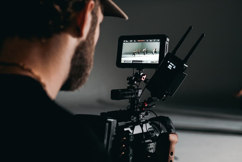 A videographer framing a shot on a camera monitor