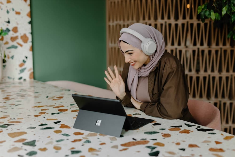 A person working through a document at a table with a laptop