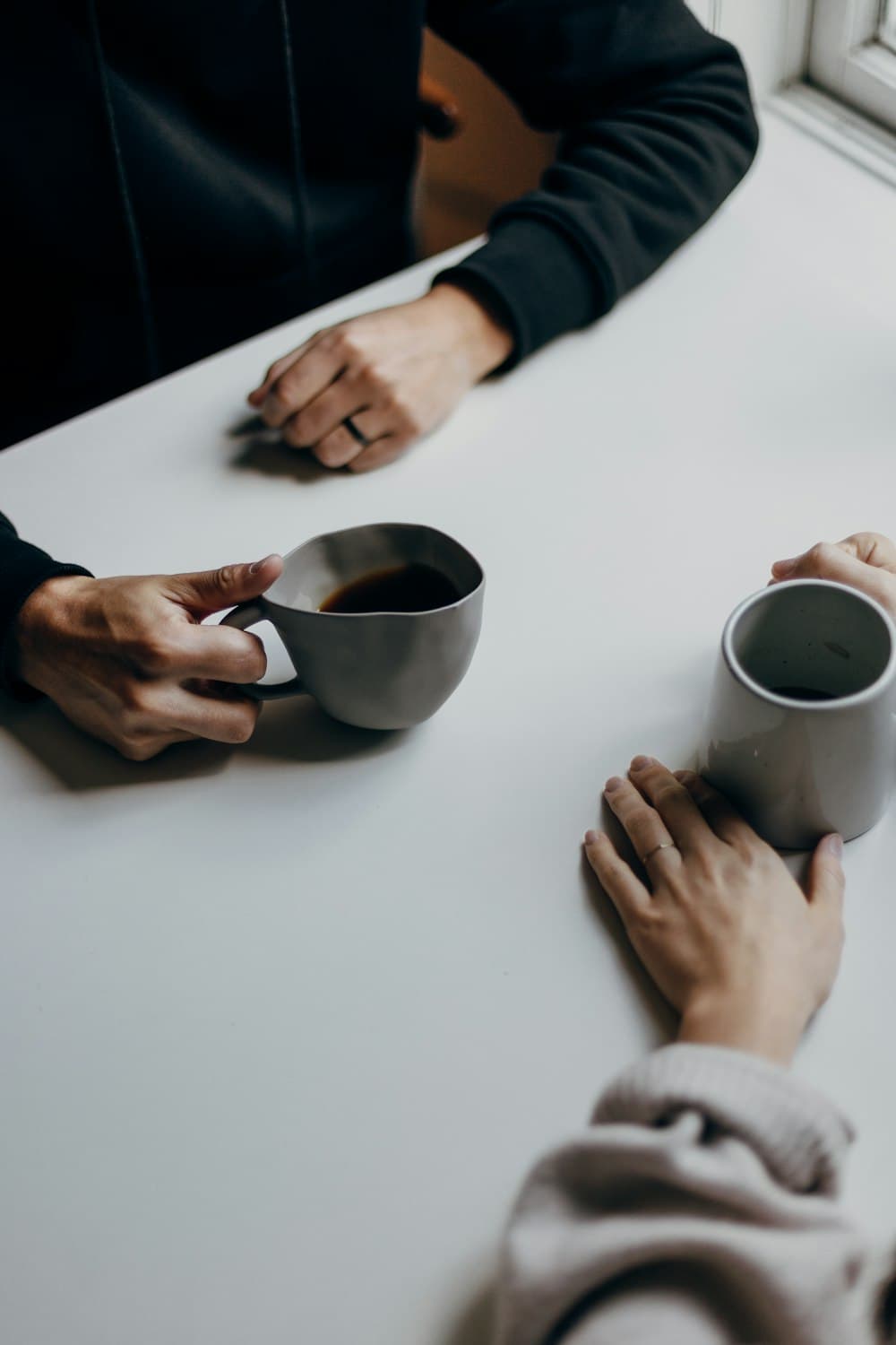 Two people talking over coffee at a table