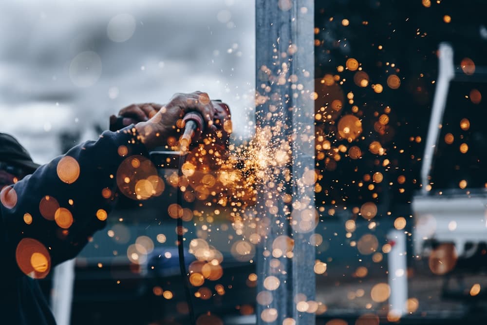 A welder working a steel column in a shower of sparks