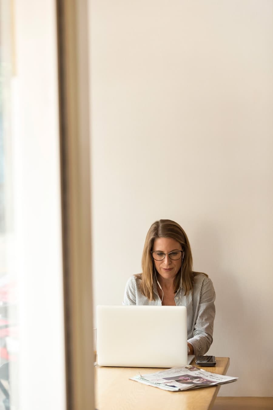 A person working at a laptop by an office window