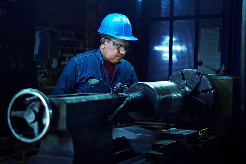 A machinist working a lathe in a workshop