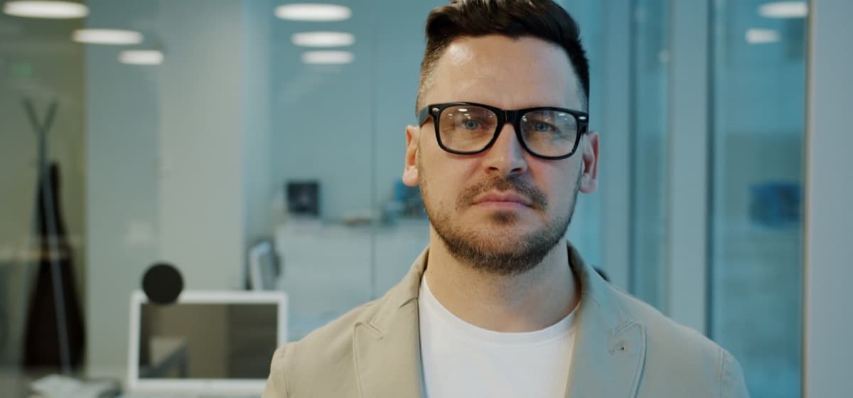 A consultant in glasses standing in a modern office