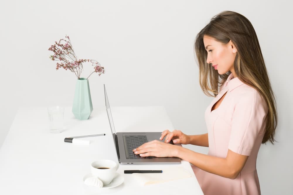 A consultant writing a proposal on a laptop