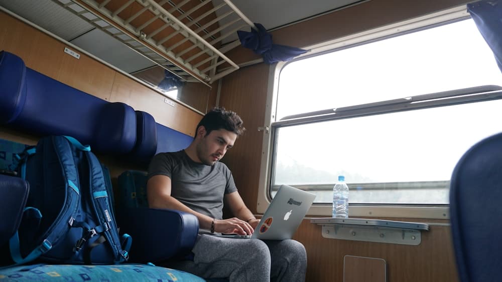 A man working on a laptop on the train home