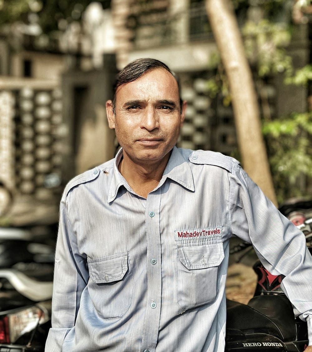 A smiling man in a grey work shirt