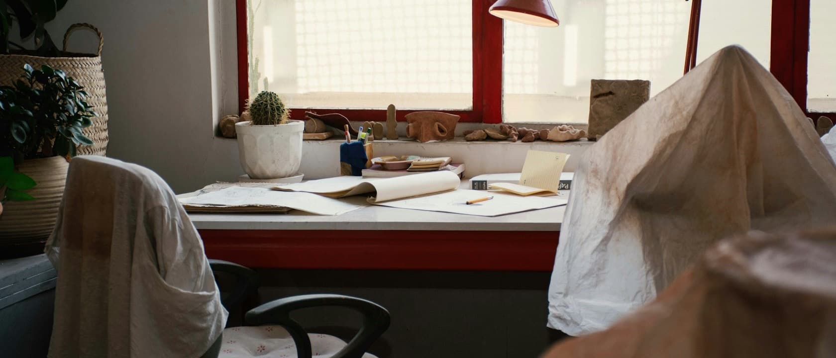 A home office desk with a lamp at the end of the day