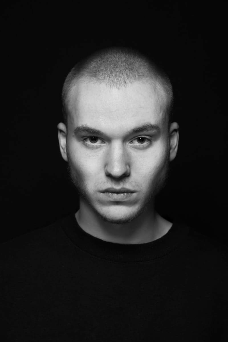 A man in a black shirt photographed in a studio