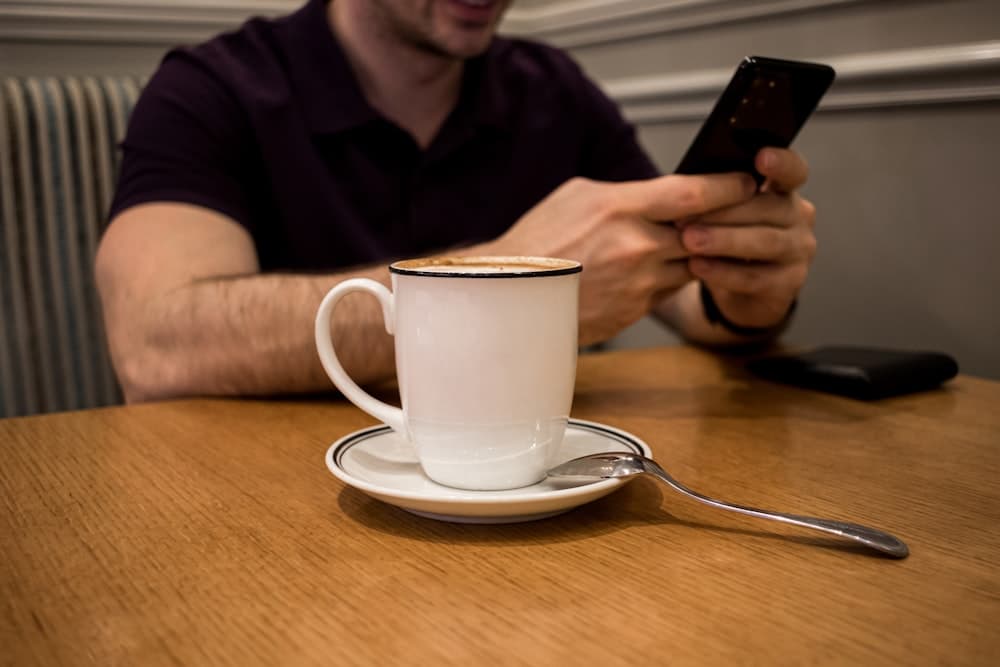 A man at a table making a call on his phone