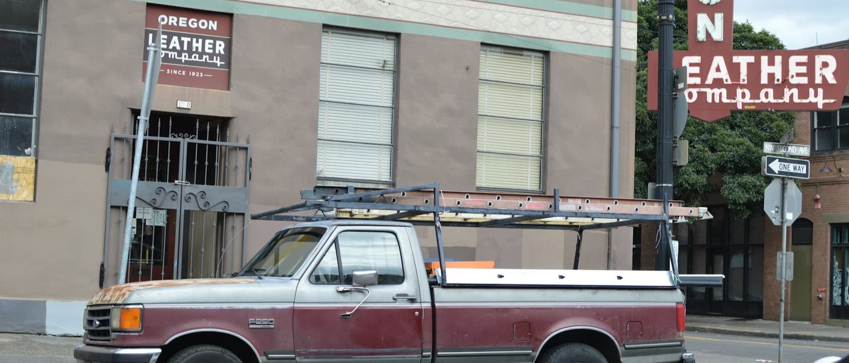 A work pickup with a ladder rack parked outside a brick building