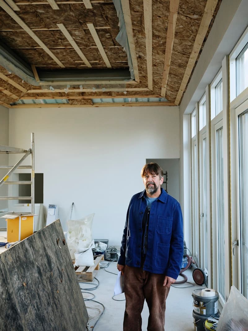 A man standing in a room that is mid-build