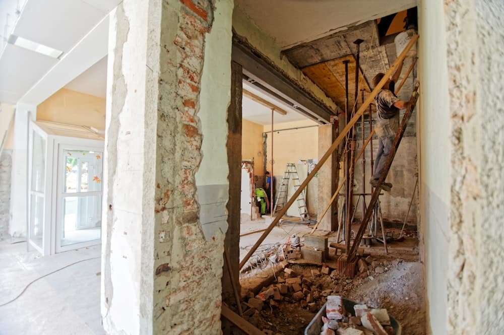 A gutted room mid-renovation with bare studs and shoring