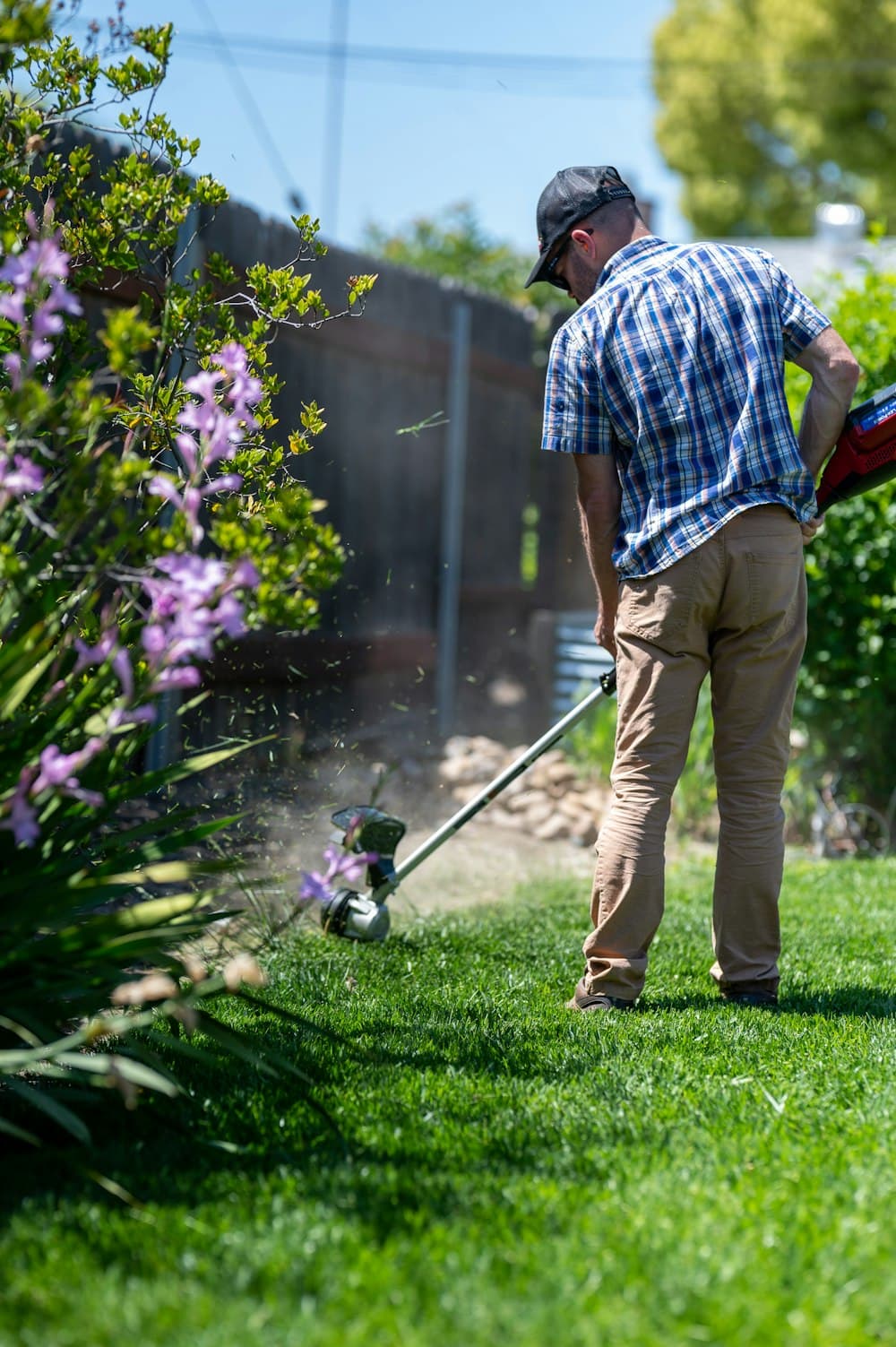 A landscaper trimming a garden bed