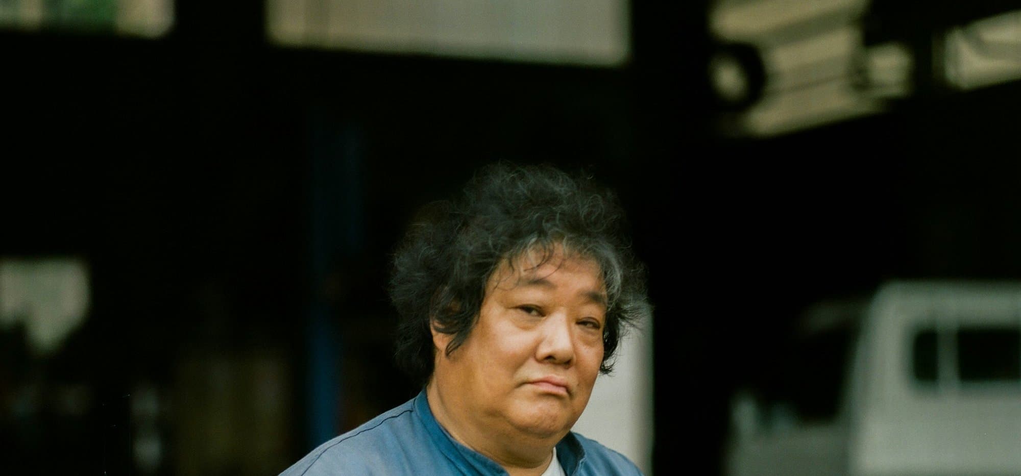 A person in work coveralls standing in the workshop doorway