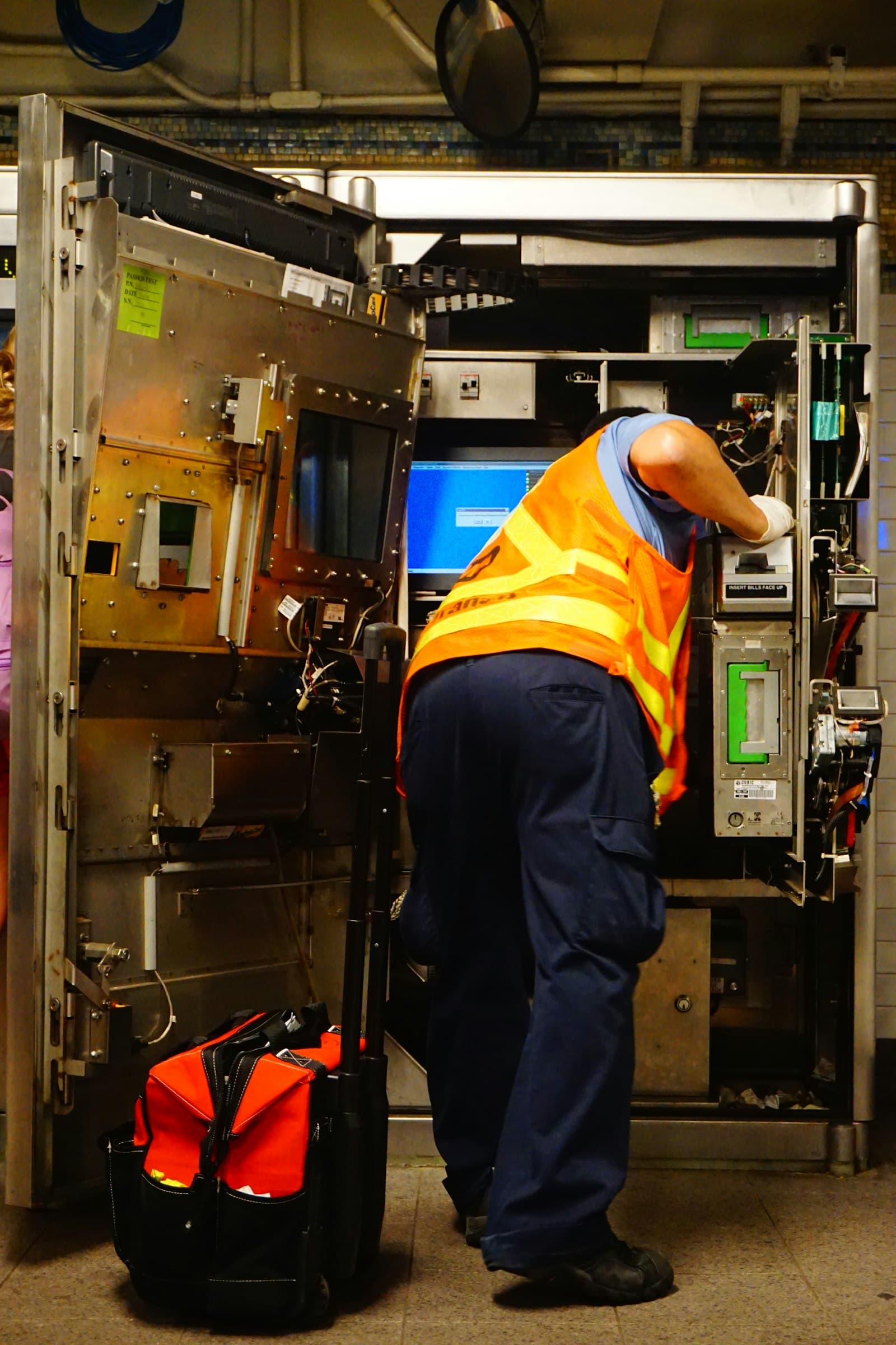 A technician in a safety vest servicing a large air handling unit