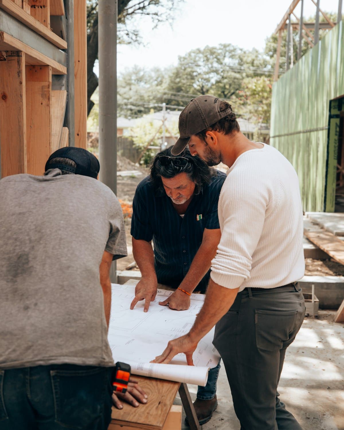 Three people reviewing plans together at a job site